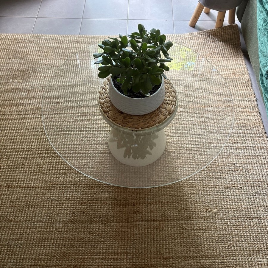 Création d’une table basse avec plateau rond en verre et socle sculptural effet pierre sur tapis tissé